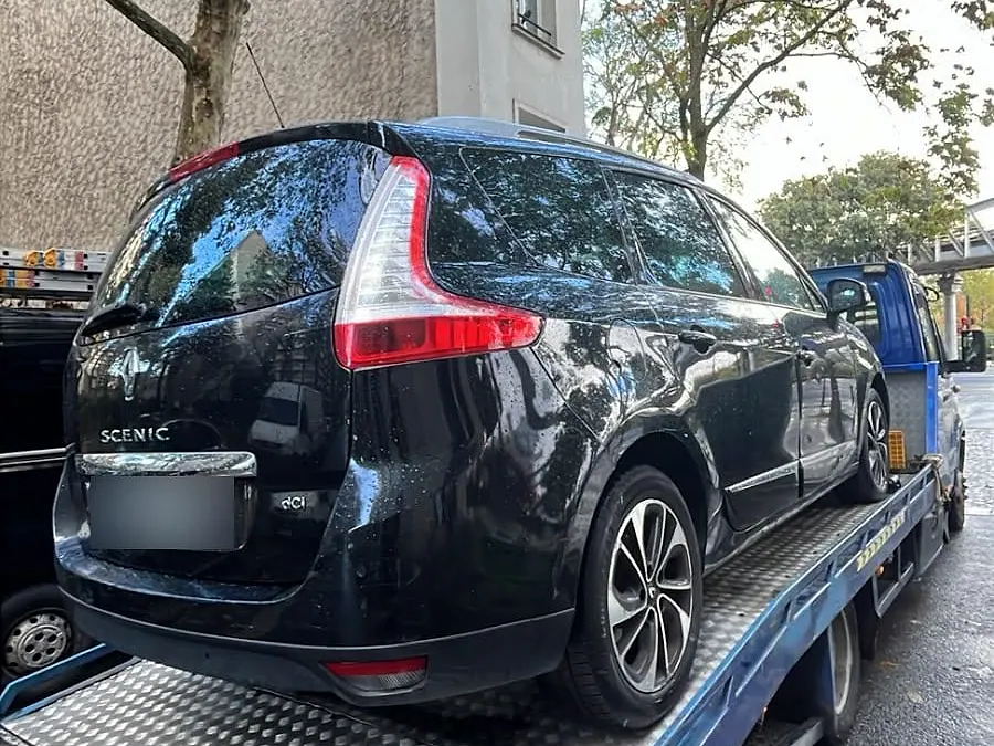 Renault Grand Scénic chargé sur notre dépanneuse plateau dans une rue de Paris